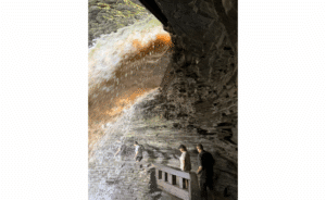 Watkins Glen Behind the Waterfall on June 10, 2025. Water is gushing with force, like coming out of a firehose, due to the recent heavy rainfall.