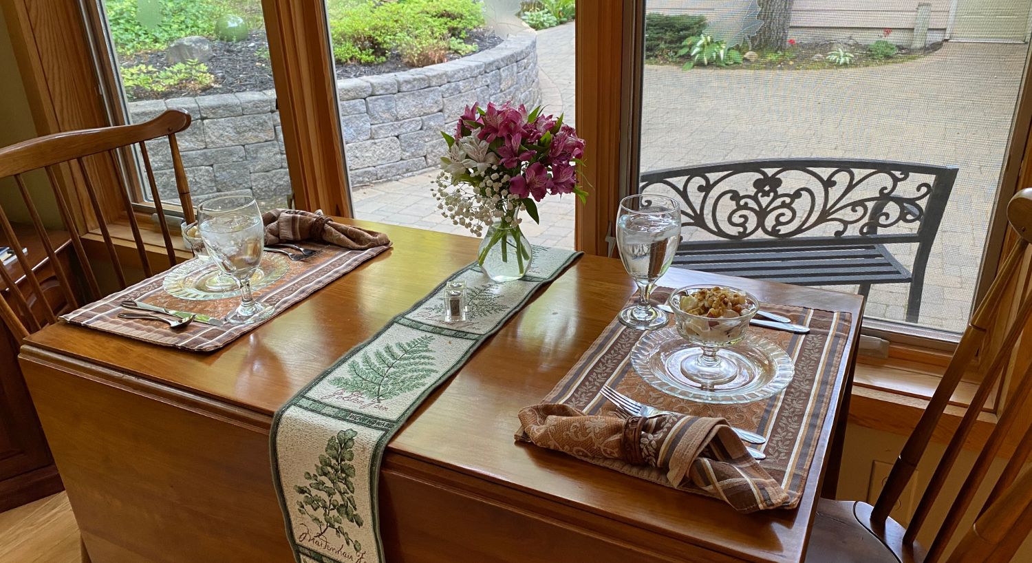 A small drop-leaf table with two chairs set for breakfast for two