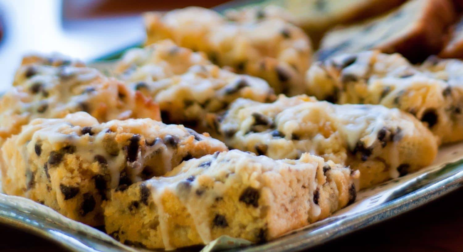 Platter full of freshly baked golden scones drizzled in icing